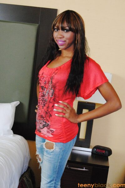 Slutty ebony chick with natural tits posing in sexy manner in hotel room Image #1